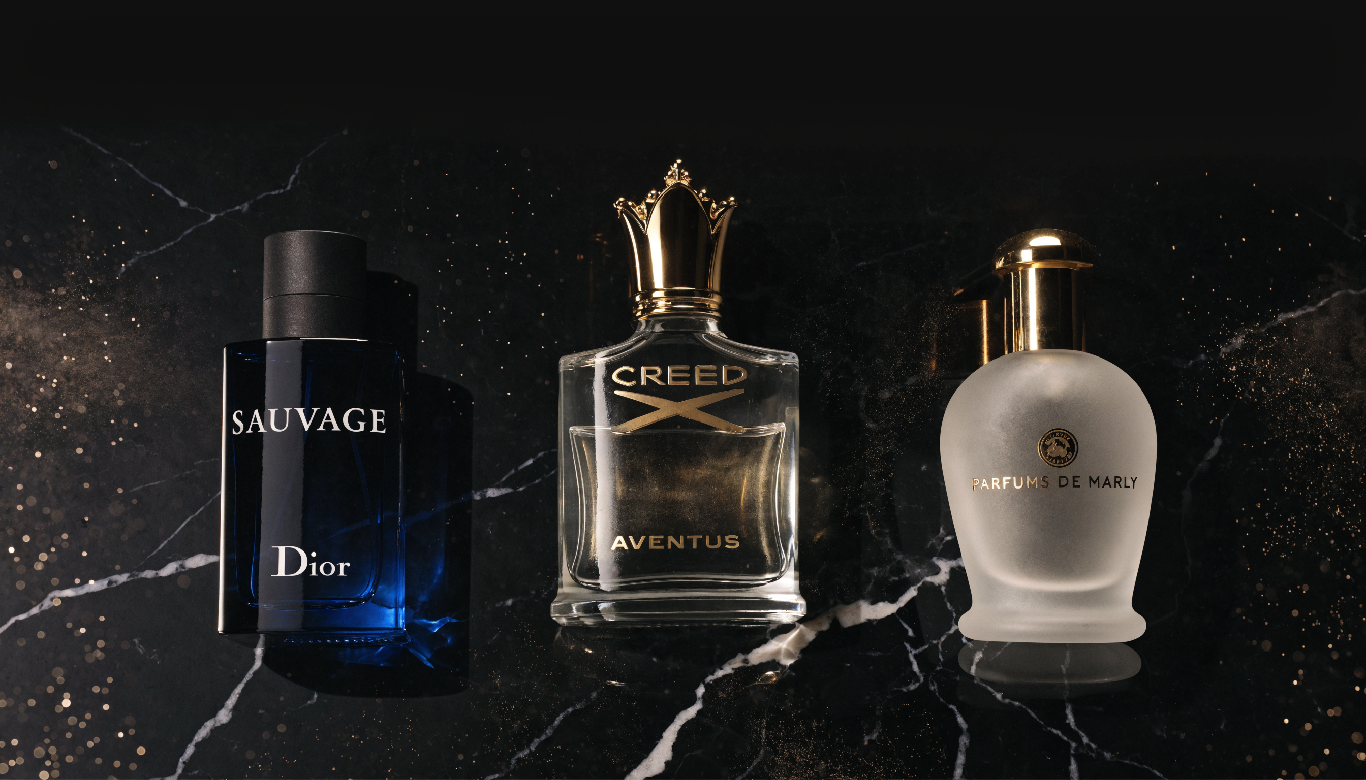 Three luxury perfume bottles on black marble